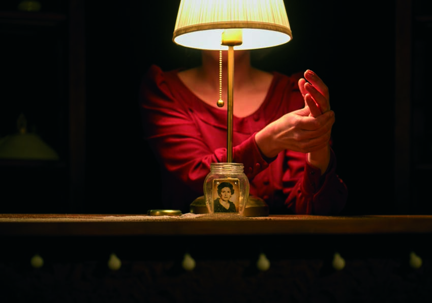 Woman behind a lamp with a photograph